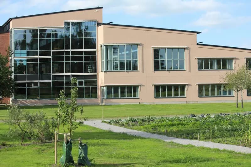 Bâtiment éducatif moderne avec grandes baies vitrées et espaces verts paysagers