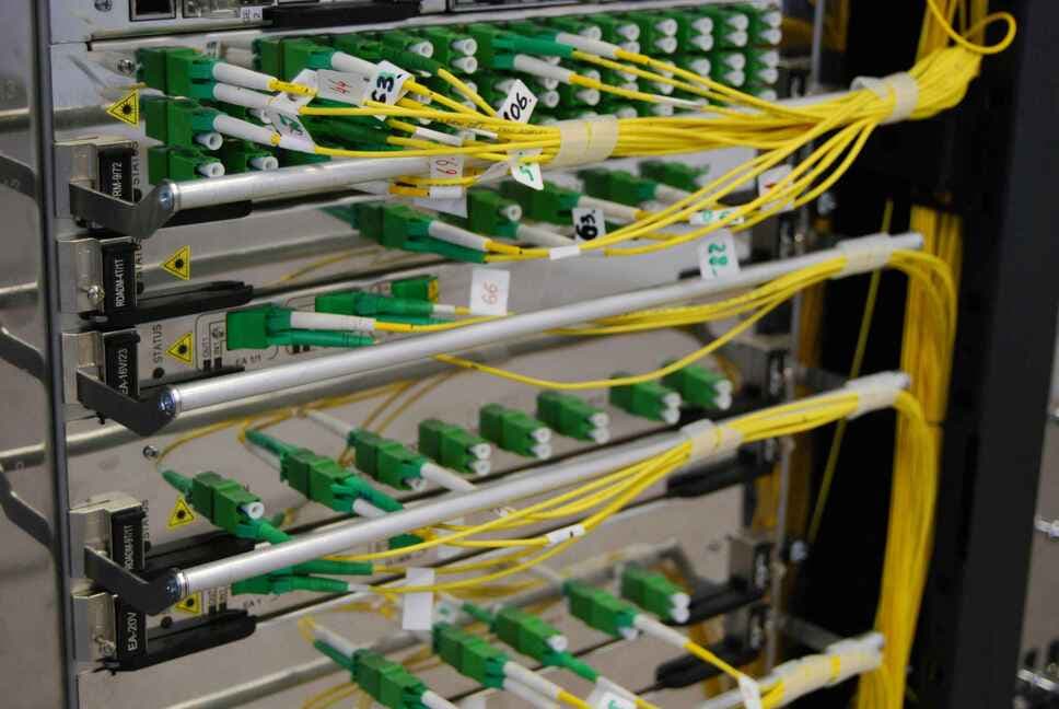 Panneau de brassage fibre optique avec connecteurs verts et câbles jaunes organisés professionnellement