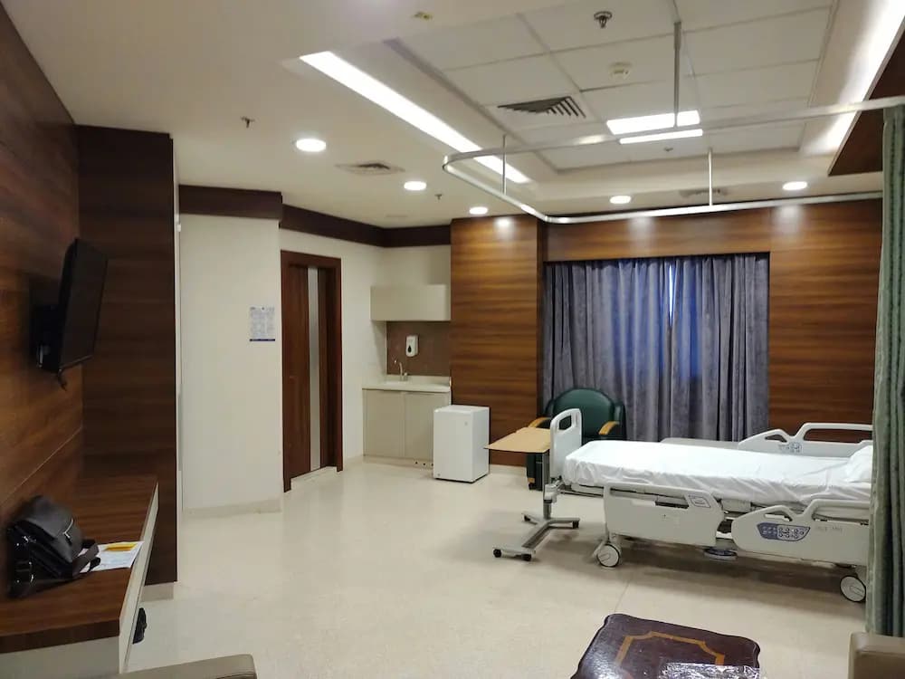 Chambre d'hôpital moderne équipée avec lit médical et technologies de confort patient