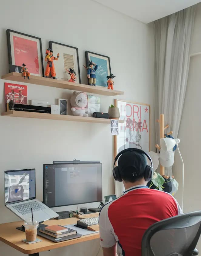 Homme travaillant à distance dans son bureau à domicile avec casque audio et ordinateurs